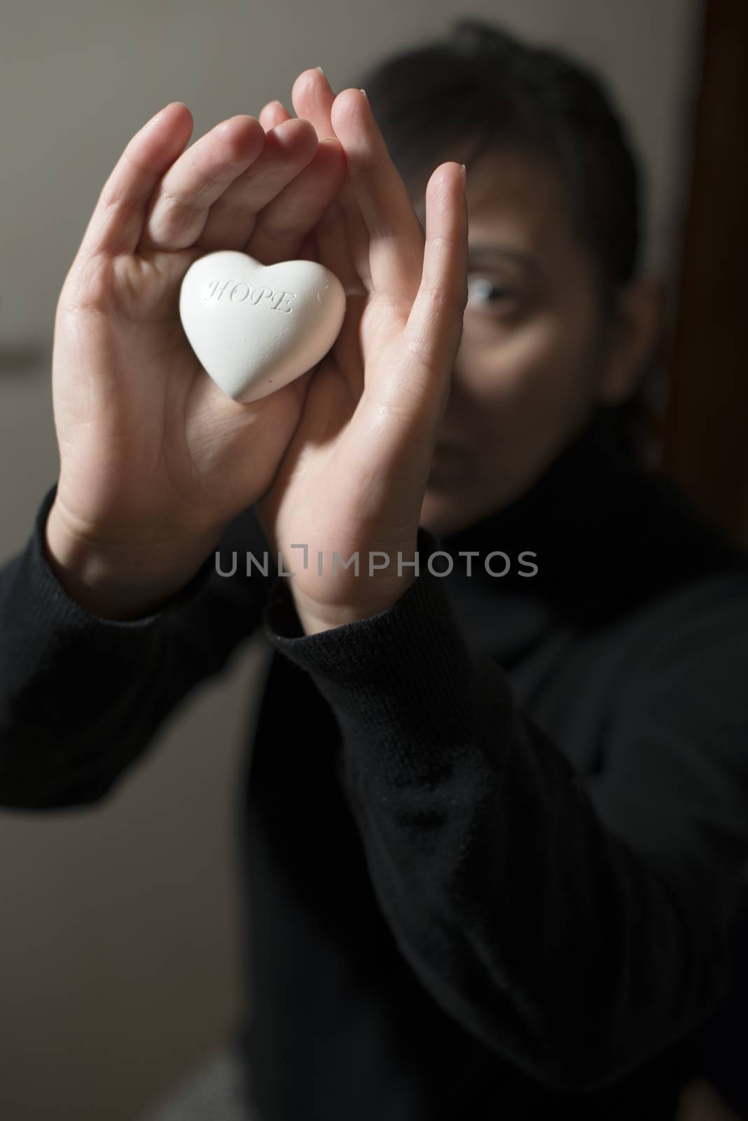 Woman hold in hands heart. Text hope by deyan_georgiev