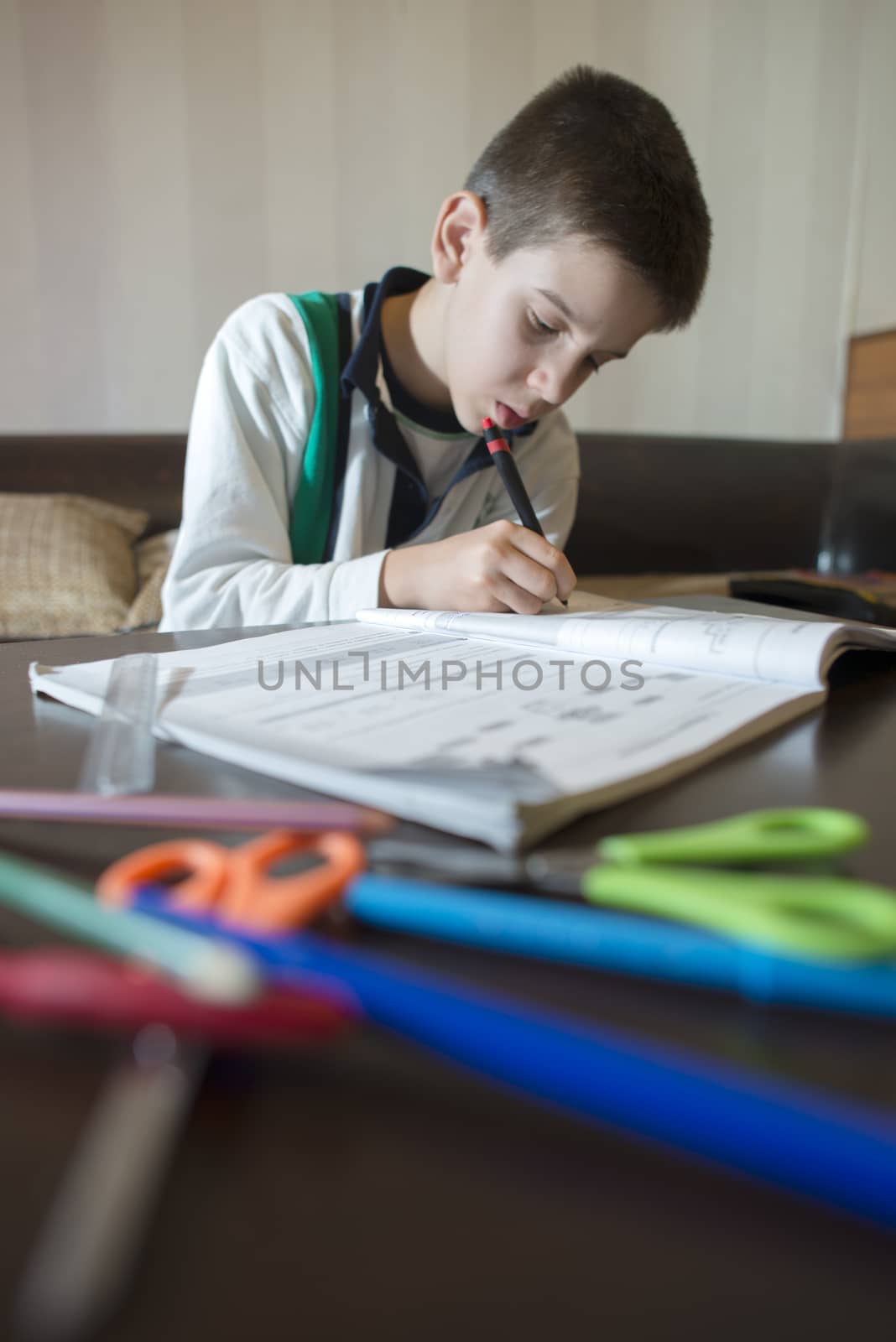 Child do his homework. Notebook for mathematic. Hand hold pen. Boy learning