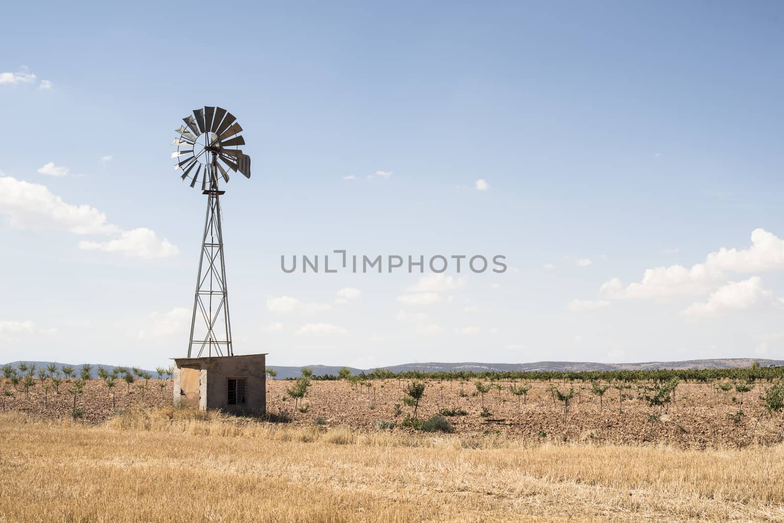 Old windmill at blue cloudy sky