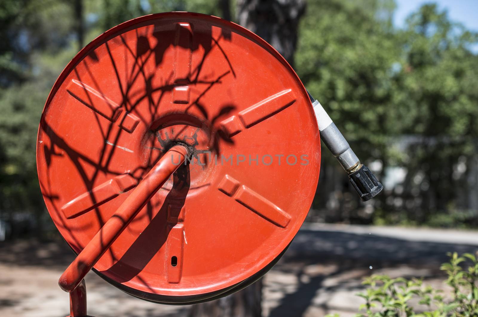 Fire extinguisher in a garden.  by deyan_georgiev