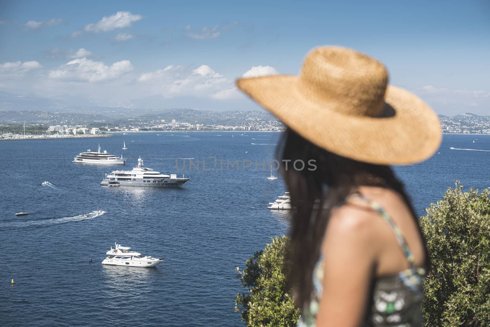 Woman with summer hat watching yachts. French riviera