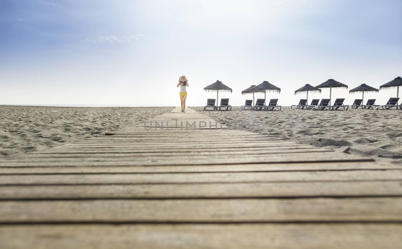 Woman with hat on the beach by deyan_georgiev