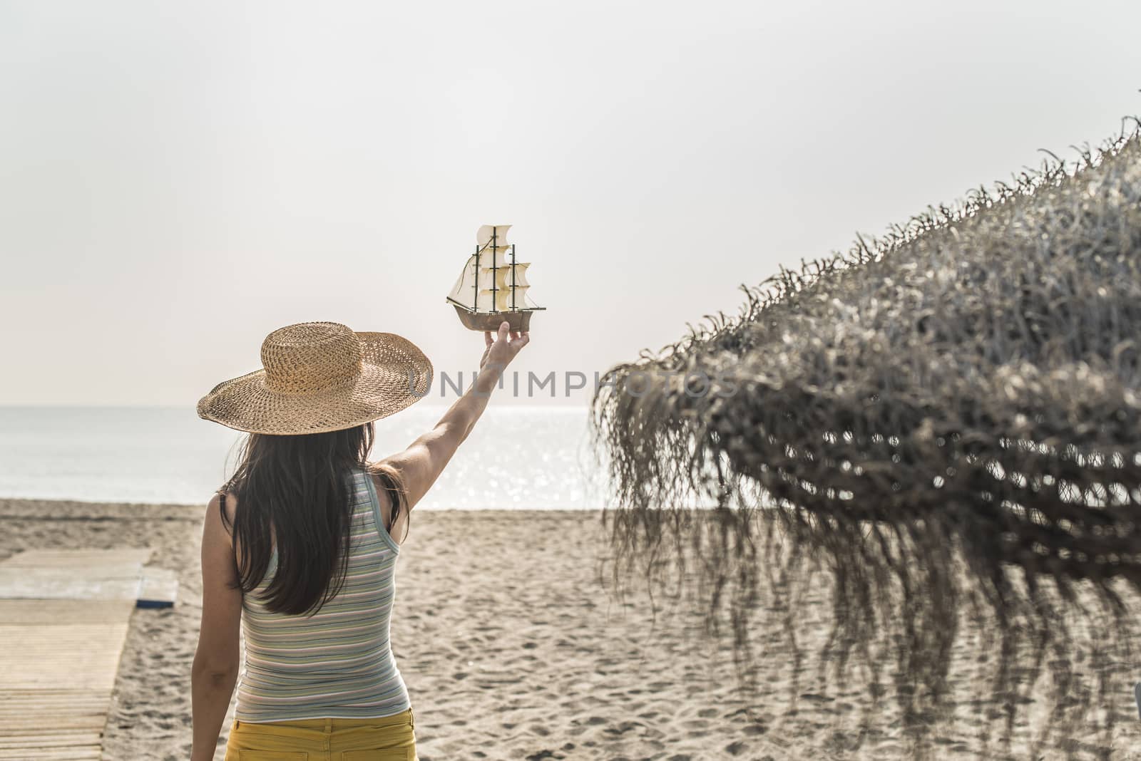 Woman hold boat model on the beach by deyan_georgiev