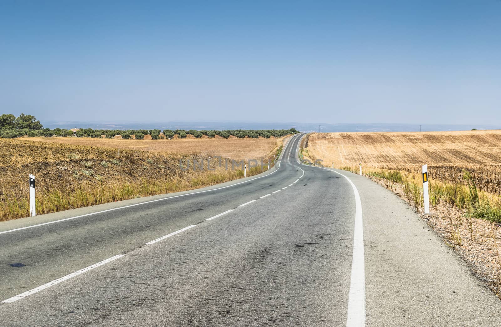 Long asphalt road and blue sky.