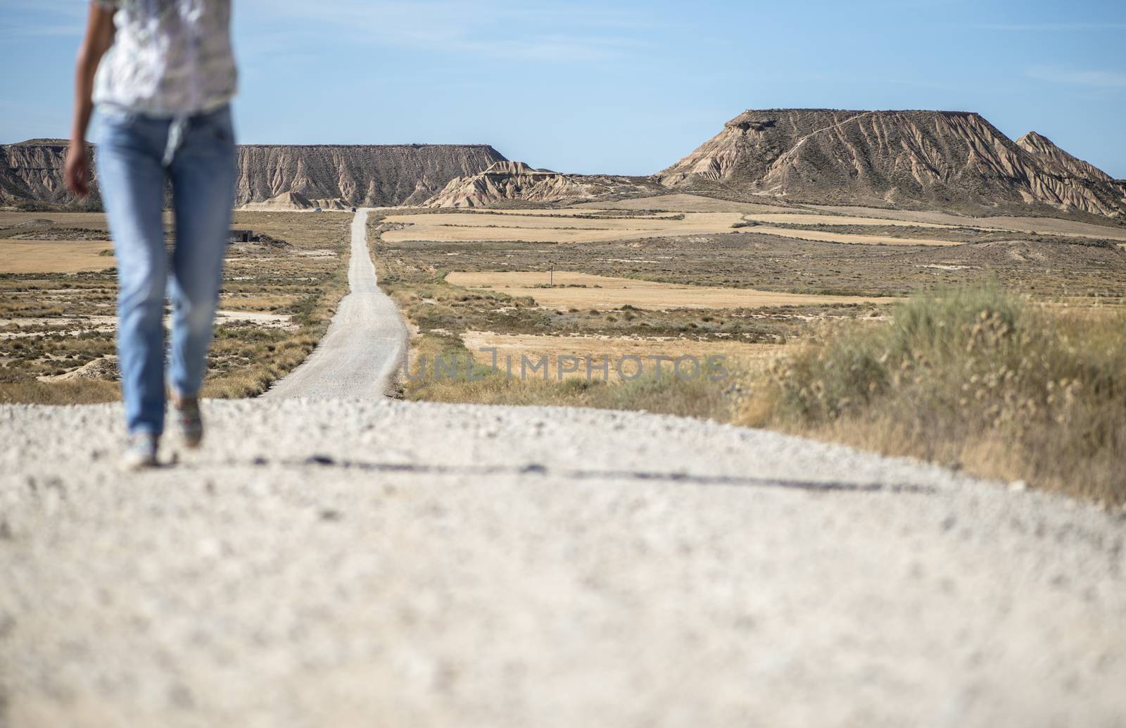 Woman walking on dirt road. Looking like a movie