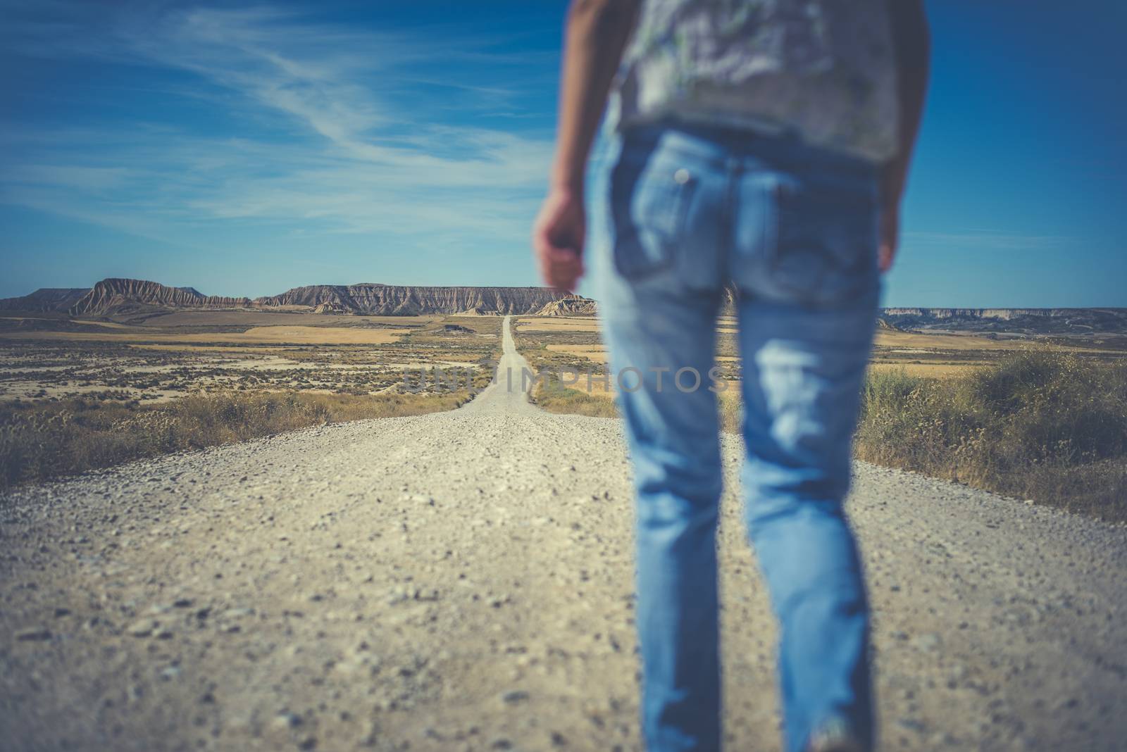 Woman walking on dirt road. Looking like a movie