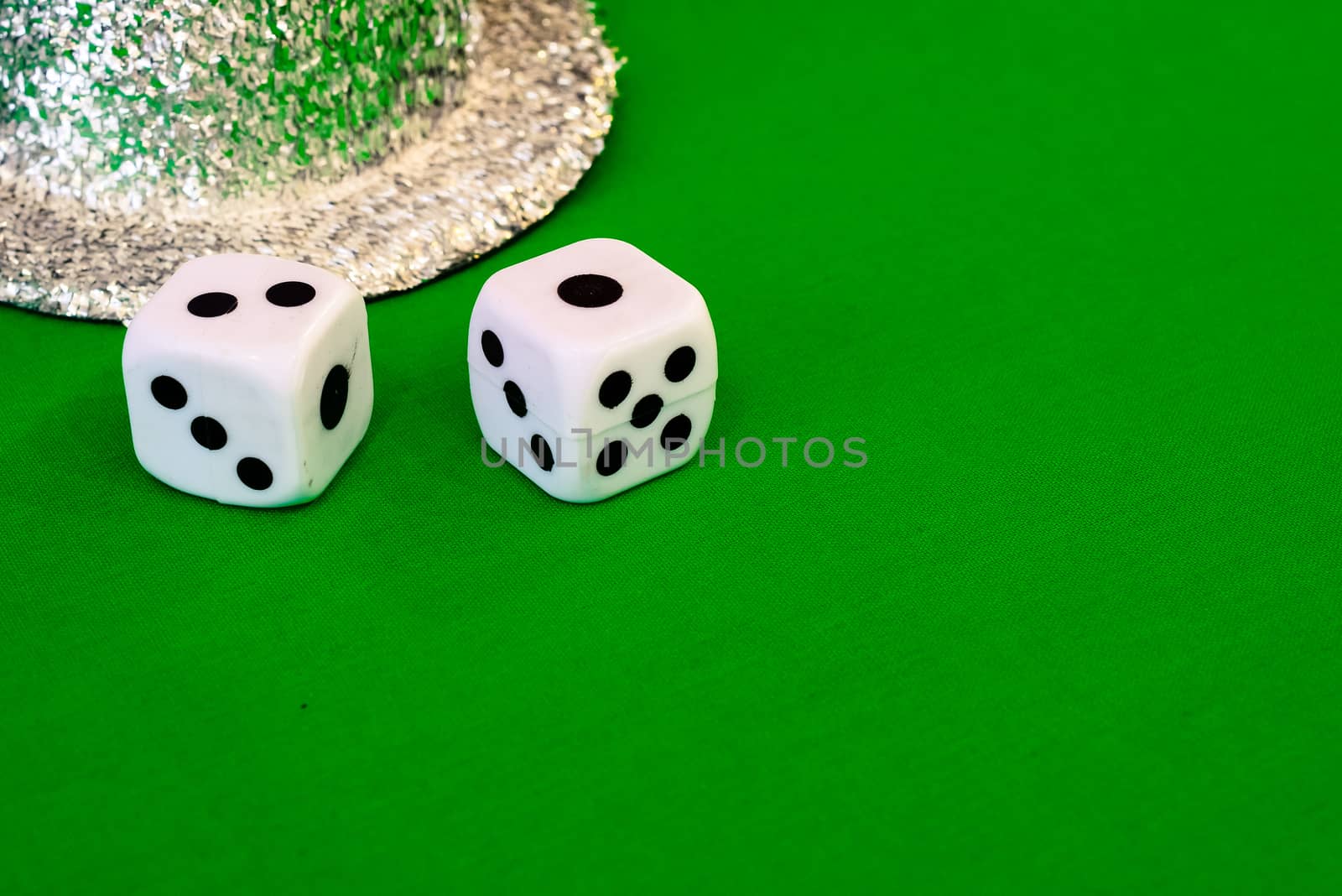 white dice on green cloth or tablecloth