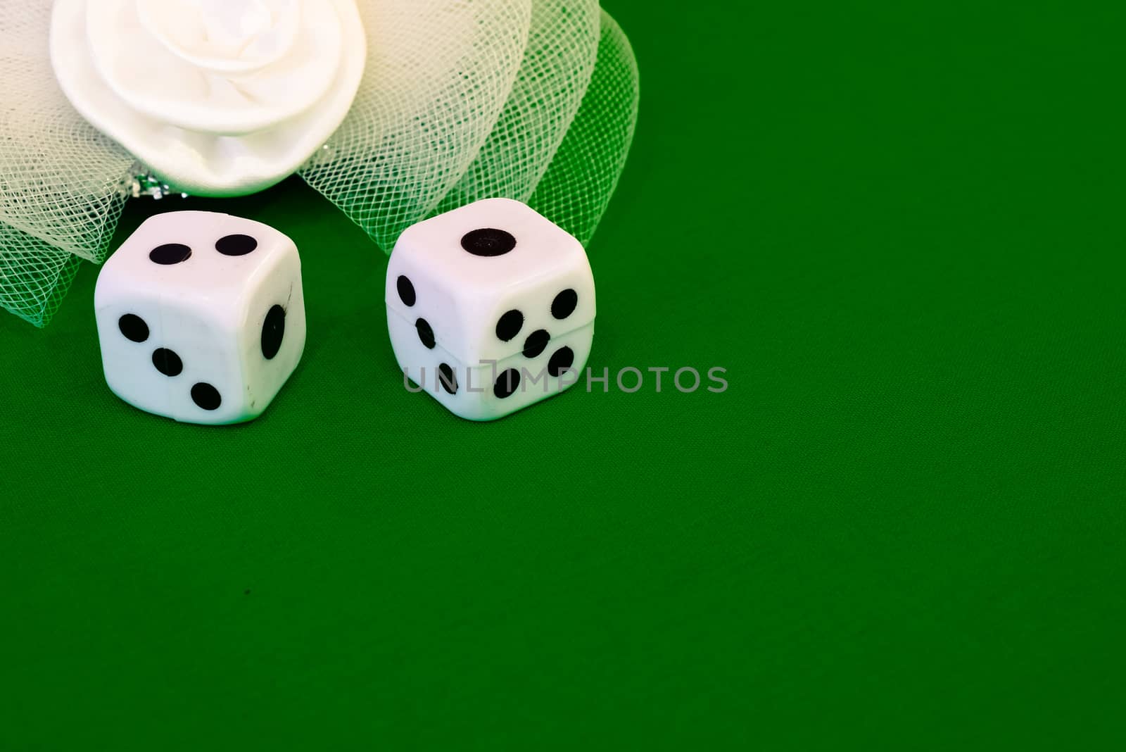 white dice on green cloth or tablecloth