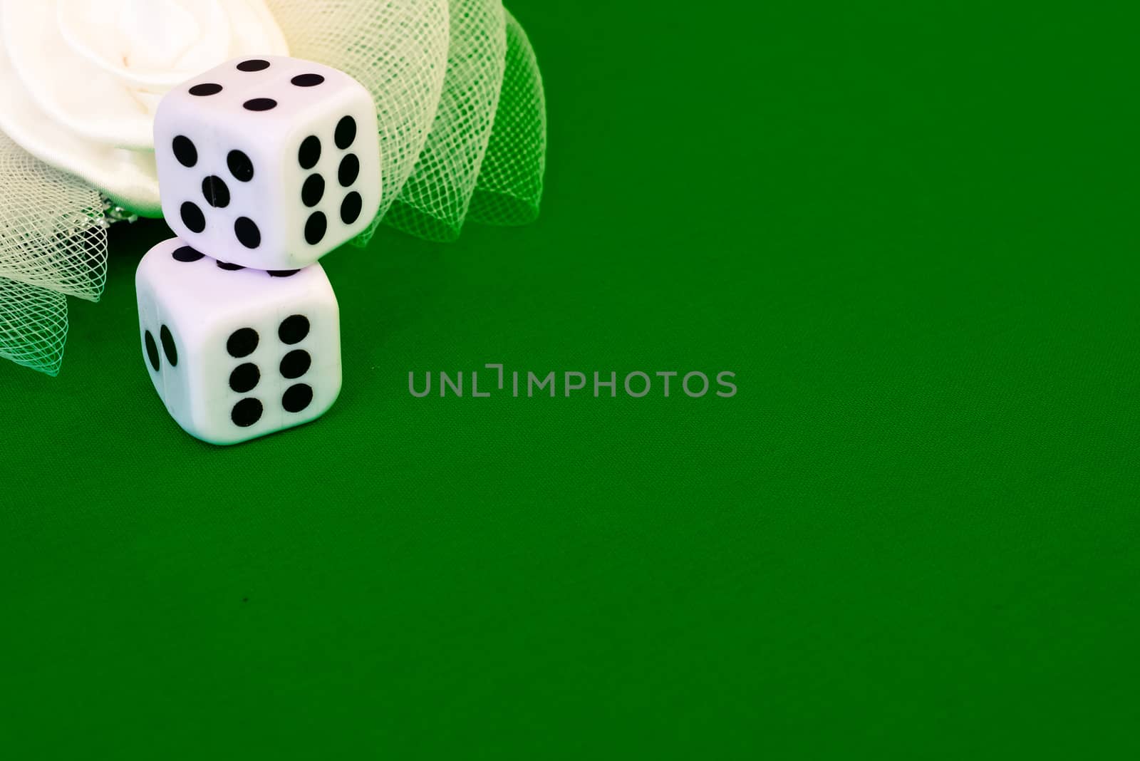 white dice on green cloth or tablecloth