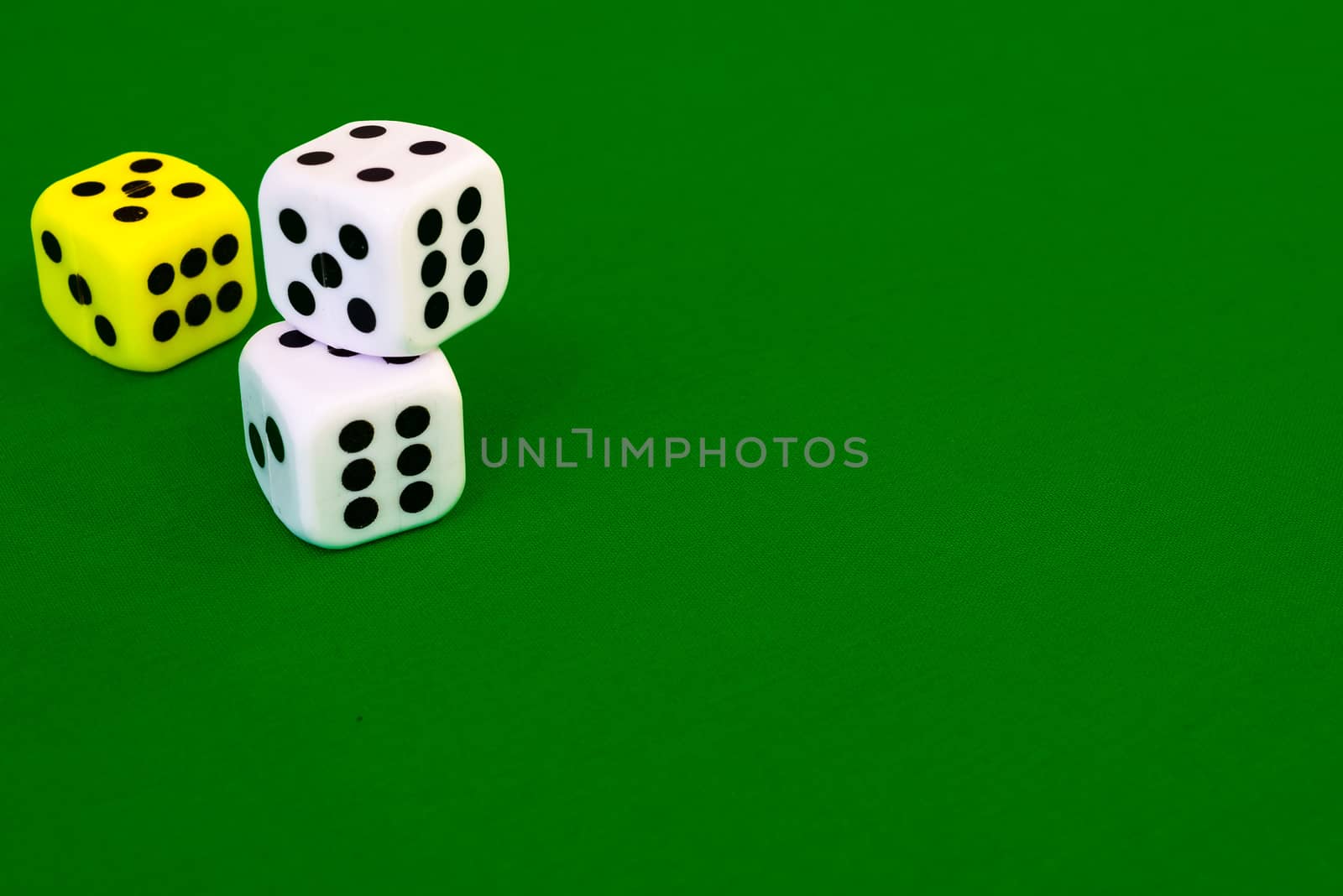 white dice on green cloth or tablecloth