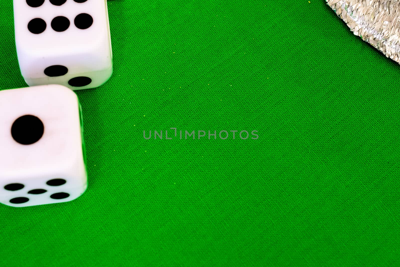 white dice on green cloth or tablecloth