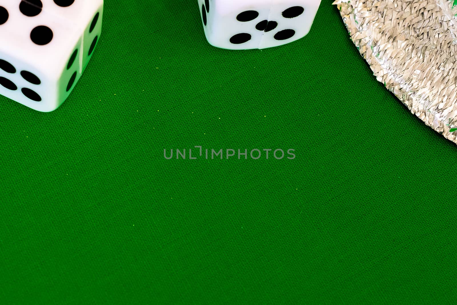 white dice on green cloth or tablecloth