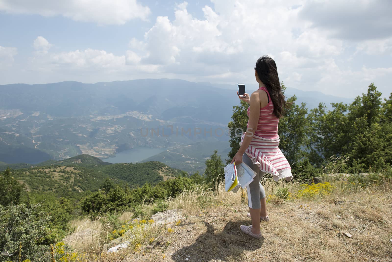 Woman taking pictures with smartphone in the forest