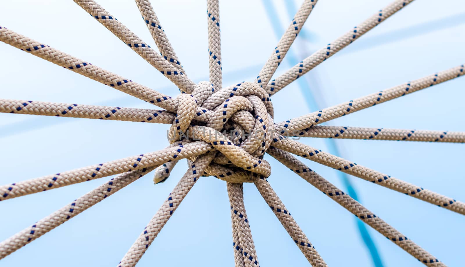 lots of ropes and a big knot against the blue sky