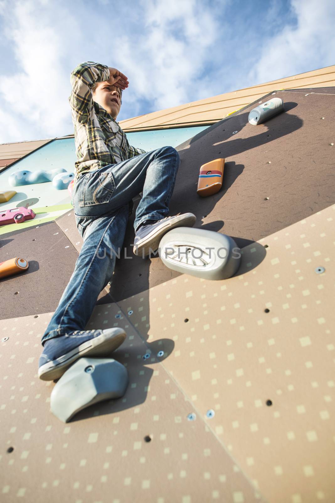 Child climb a climbing wall. Playground