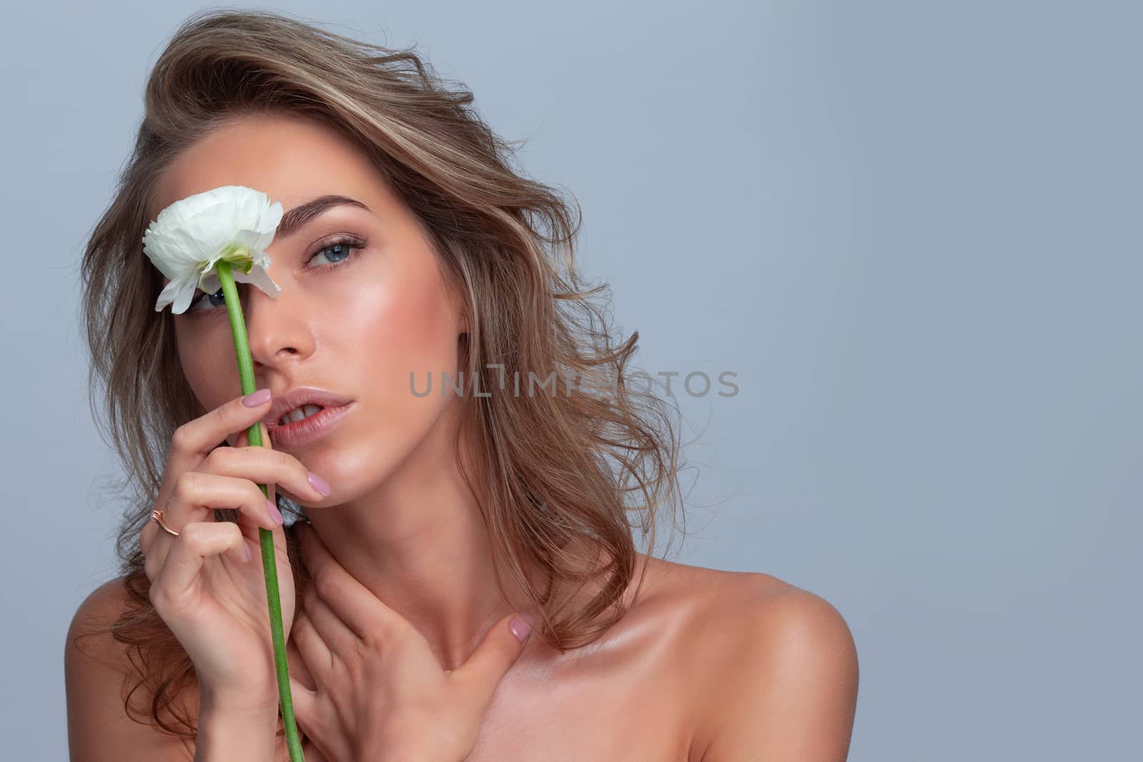 Studio fashion photo of beautiful young woman with white rose