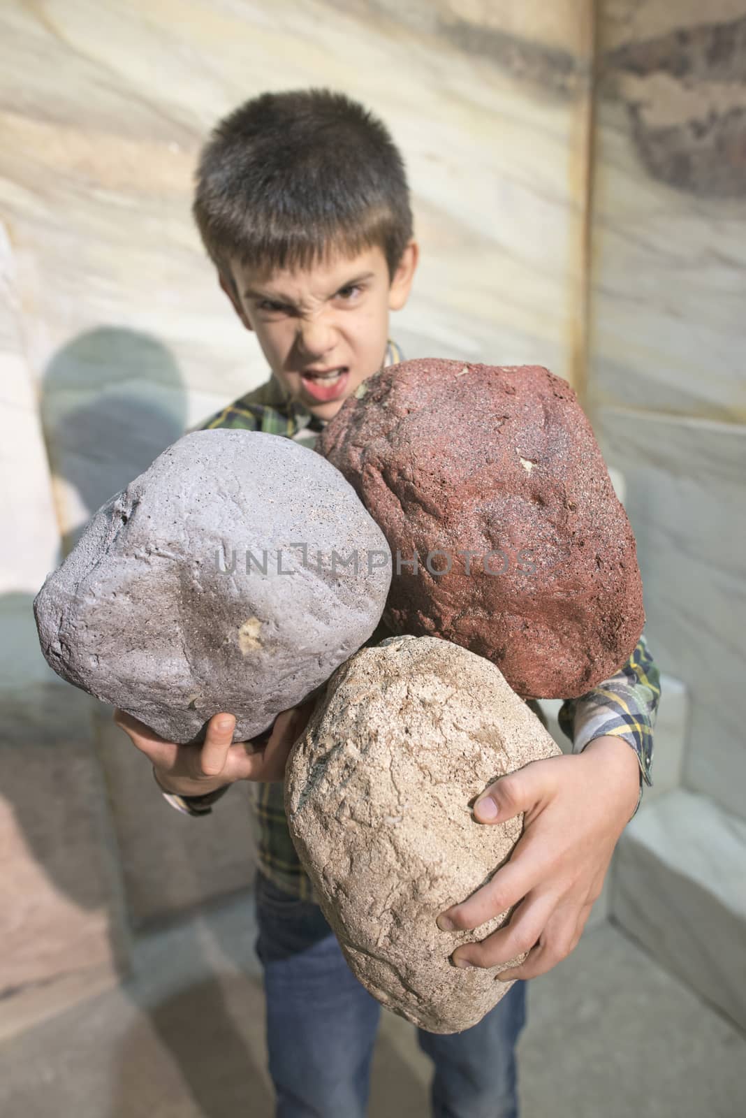 Strong child holds heavy stones by deyan_georgiev