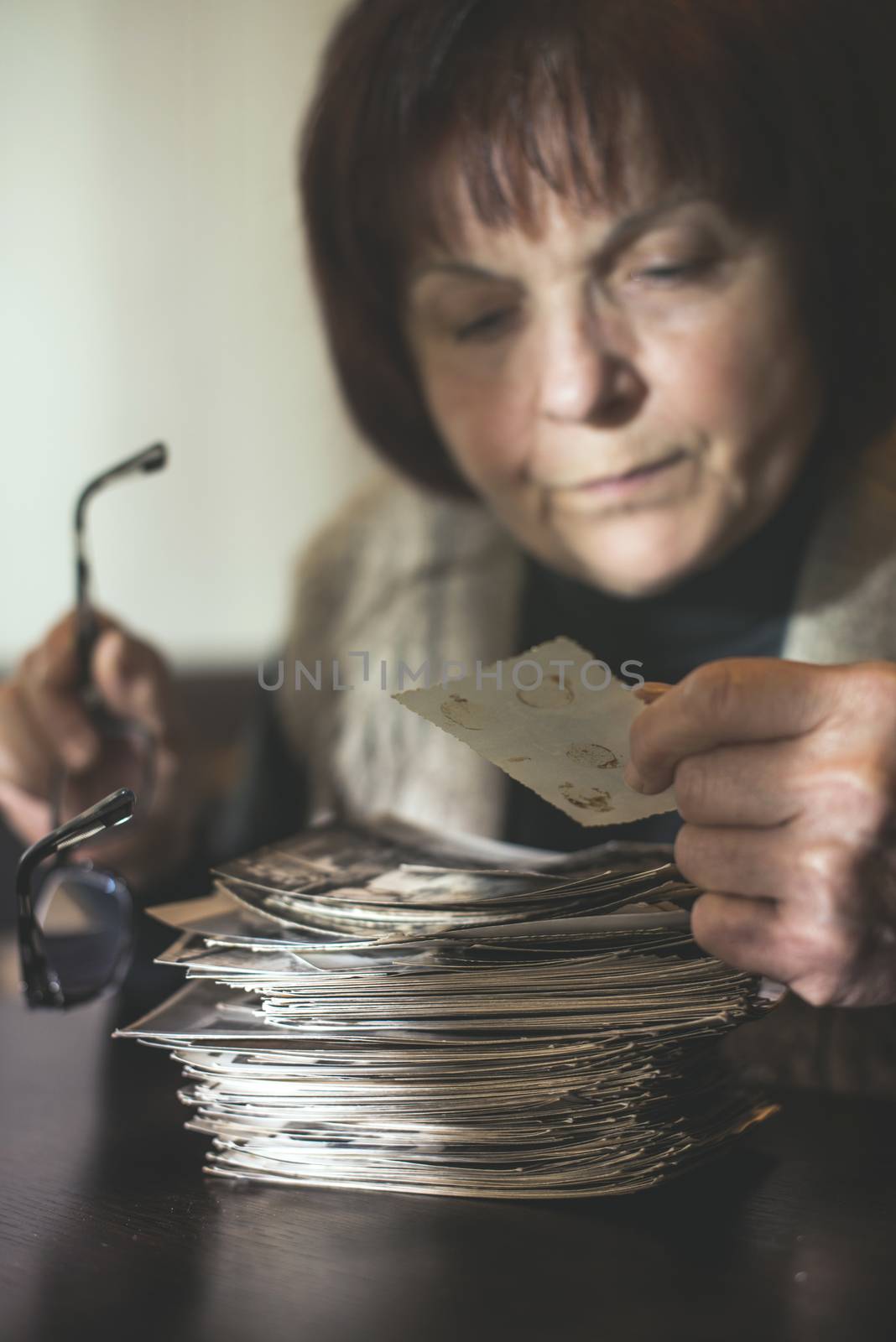Senior woman and old photos by deyan_georgiev