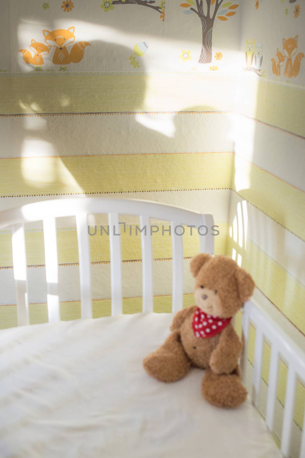 Teddy bear in a baby room. Baby and mother silhouette on the wall.