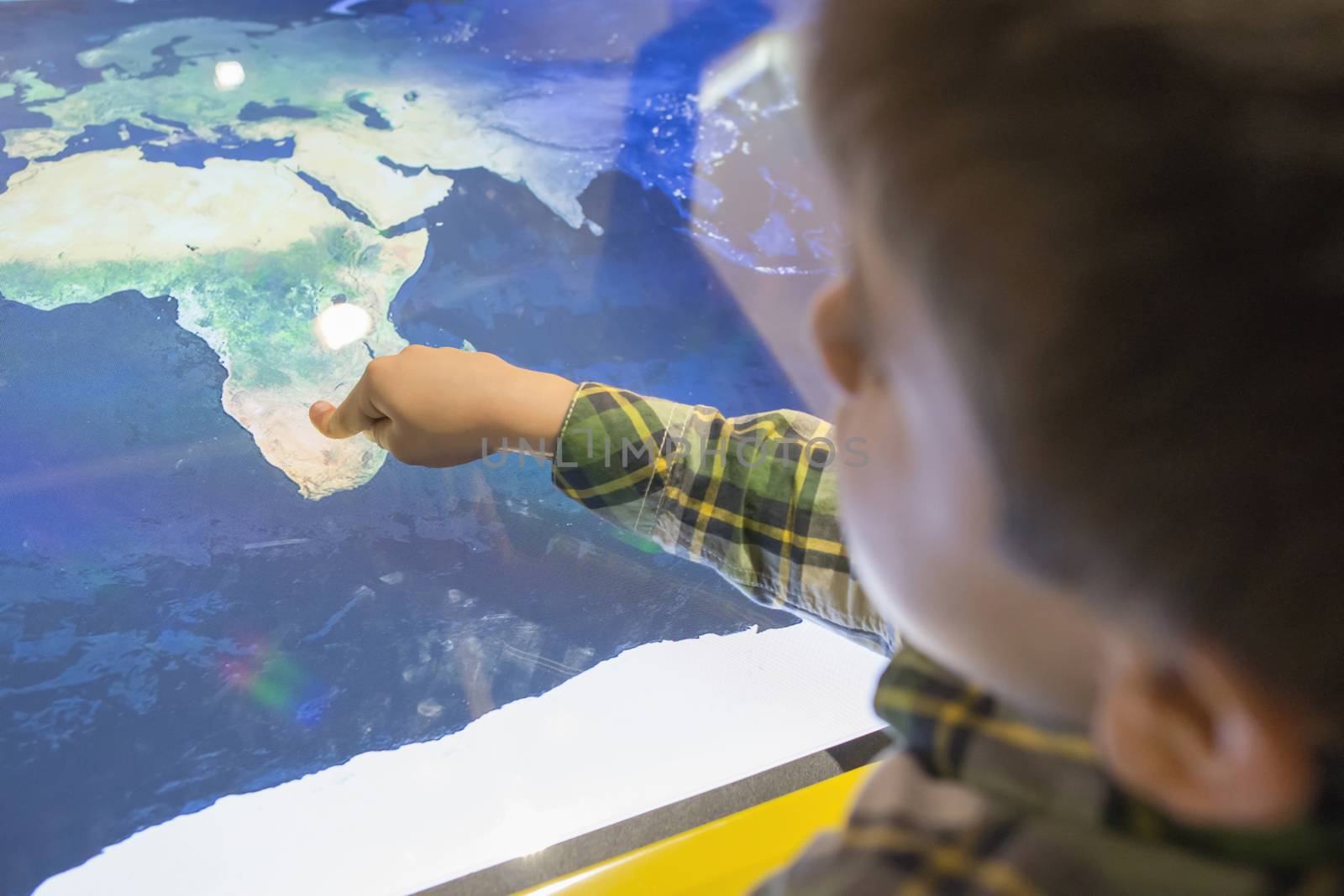 Child pointing Africa on a map.