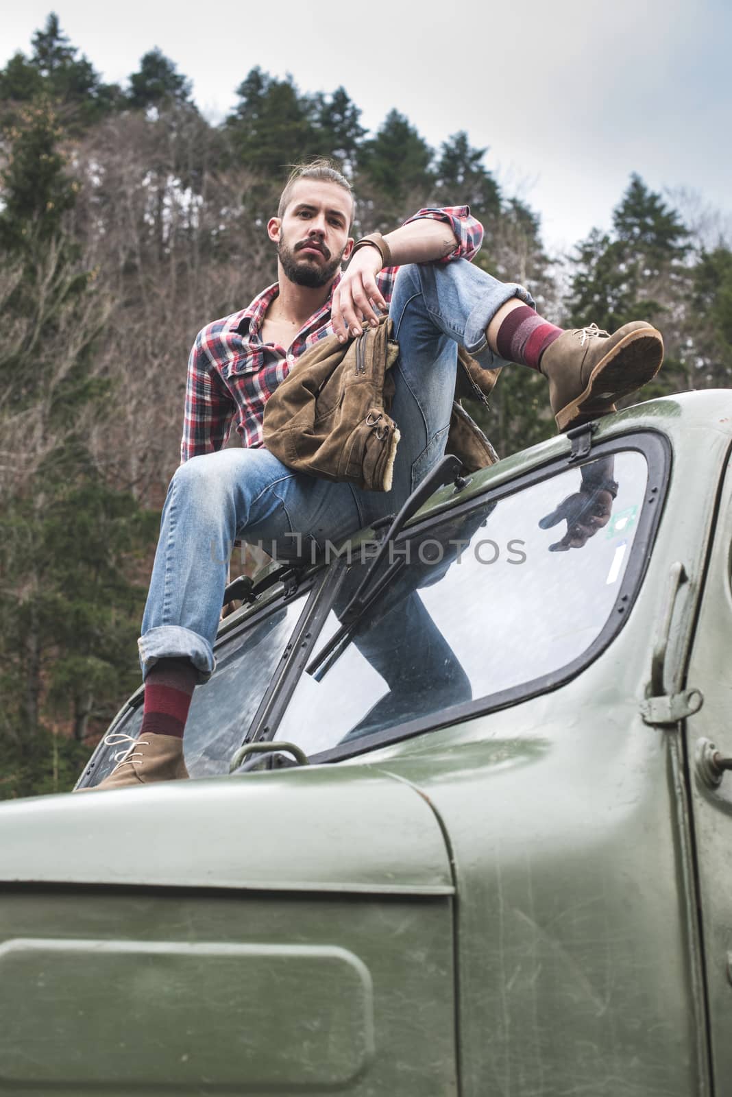 Young man on vintage truck with logs by deyan_georgiev