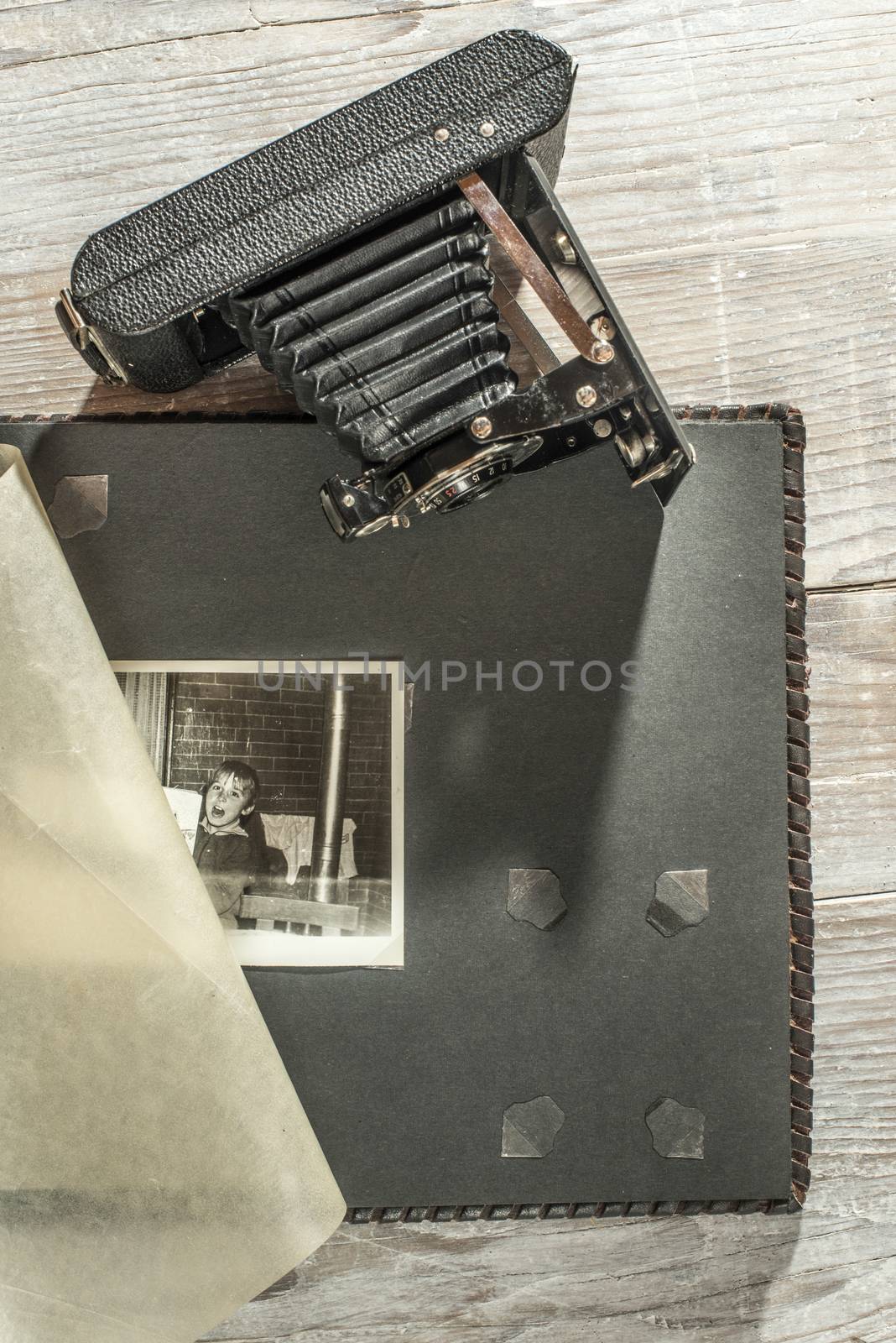 Vintage photo camera and album on white wooden background