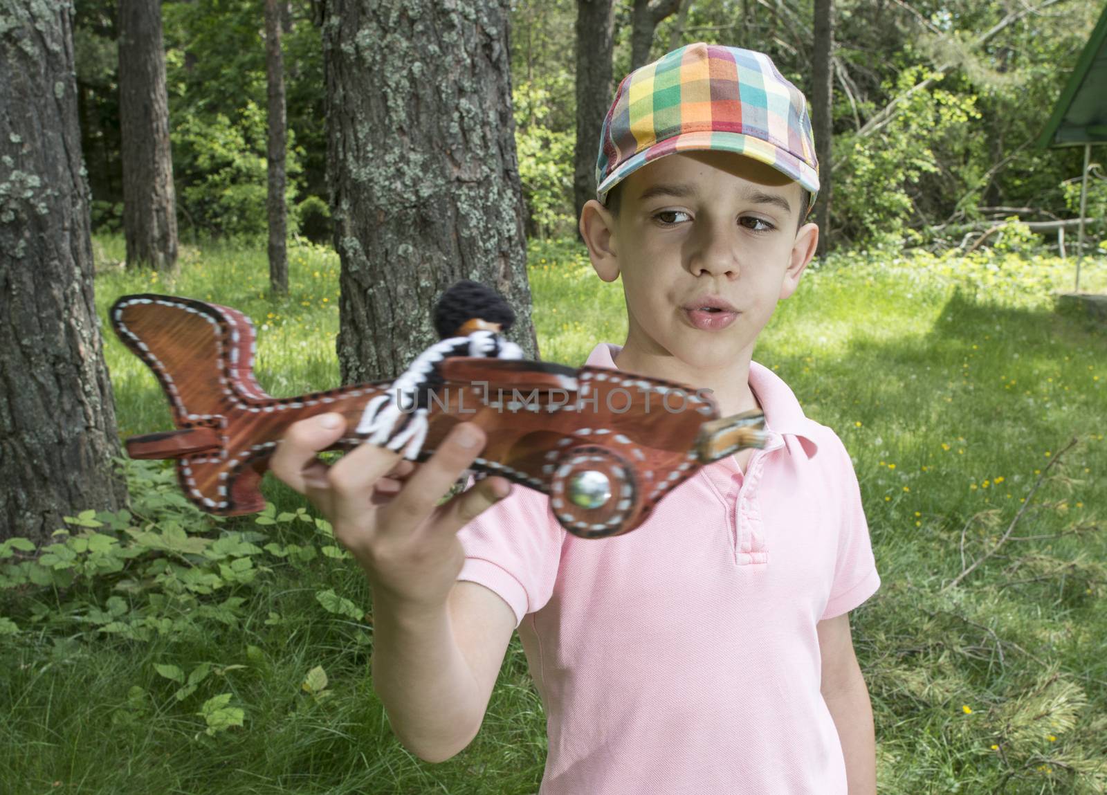 Child play with a wooden plane in the mountain. Forest