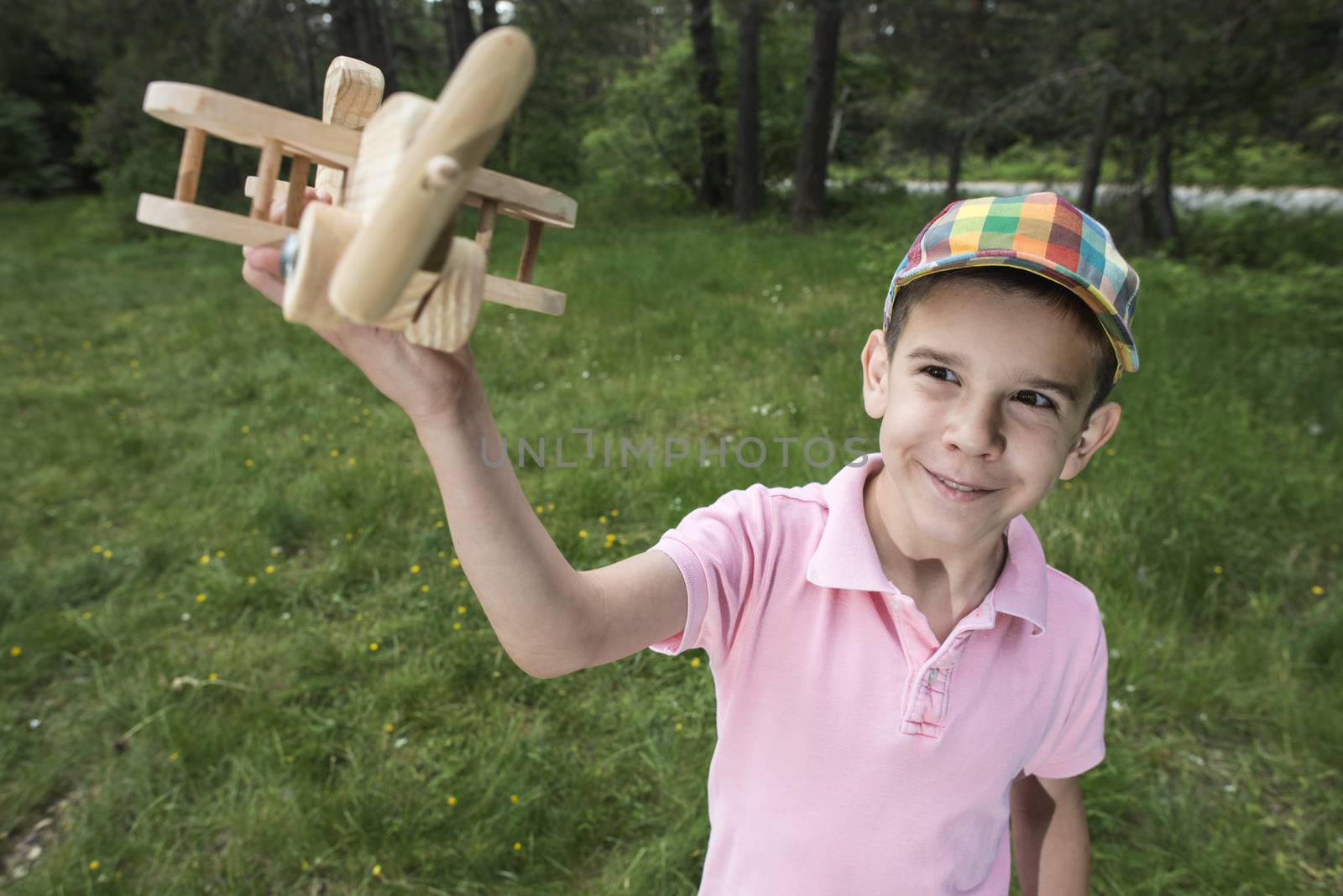 Child play with a wooden plane in the mountain. Forest