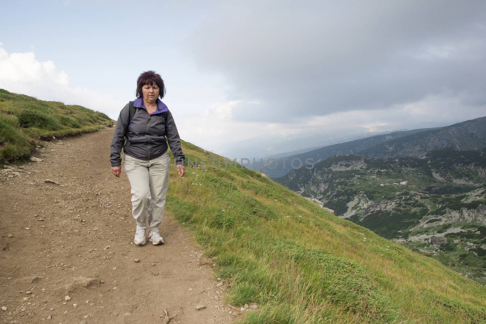 Senior woman walking in the mountain. 