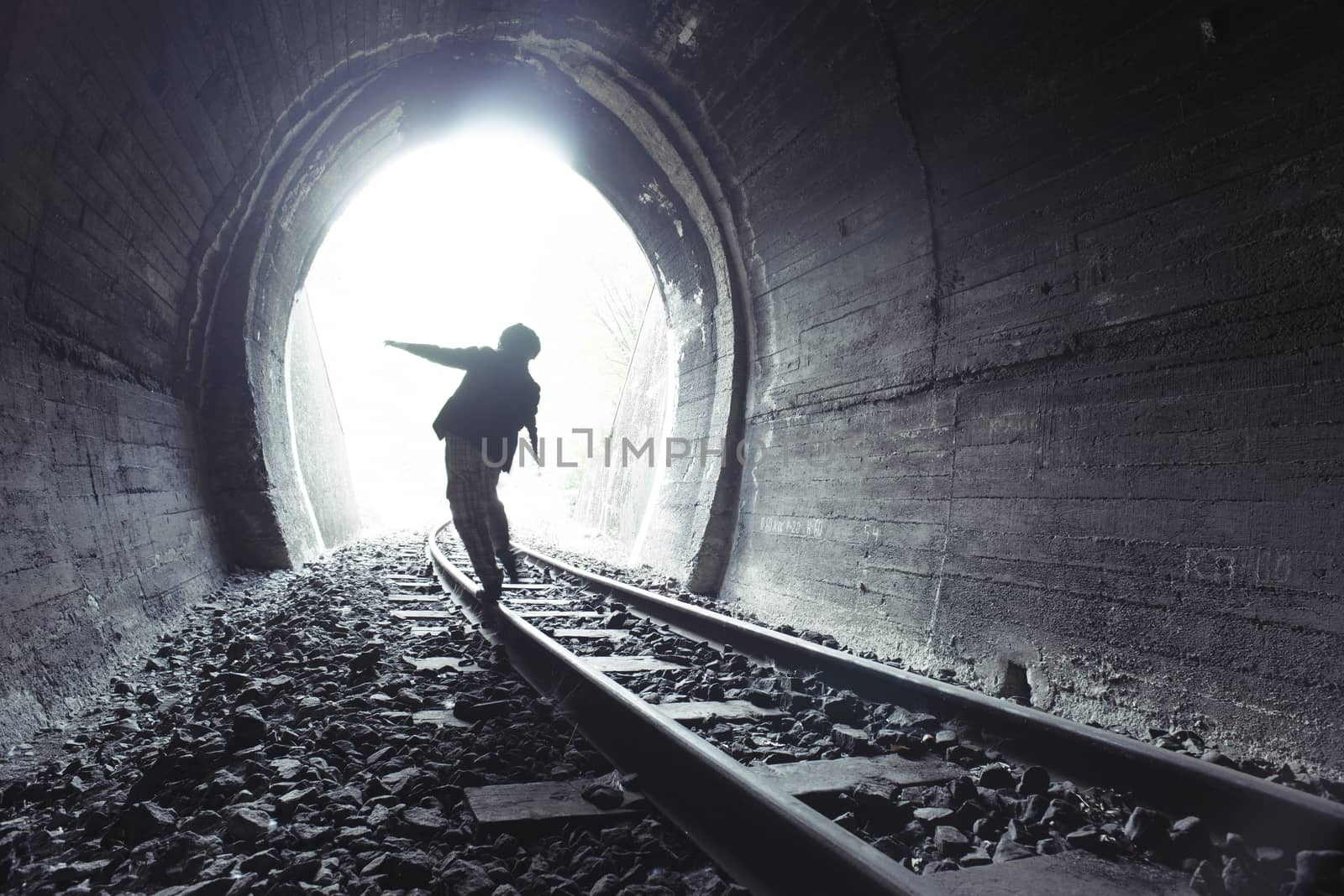 Child walking in railway tunnel. Vintage clothes