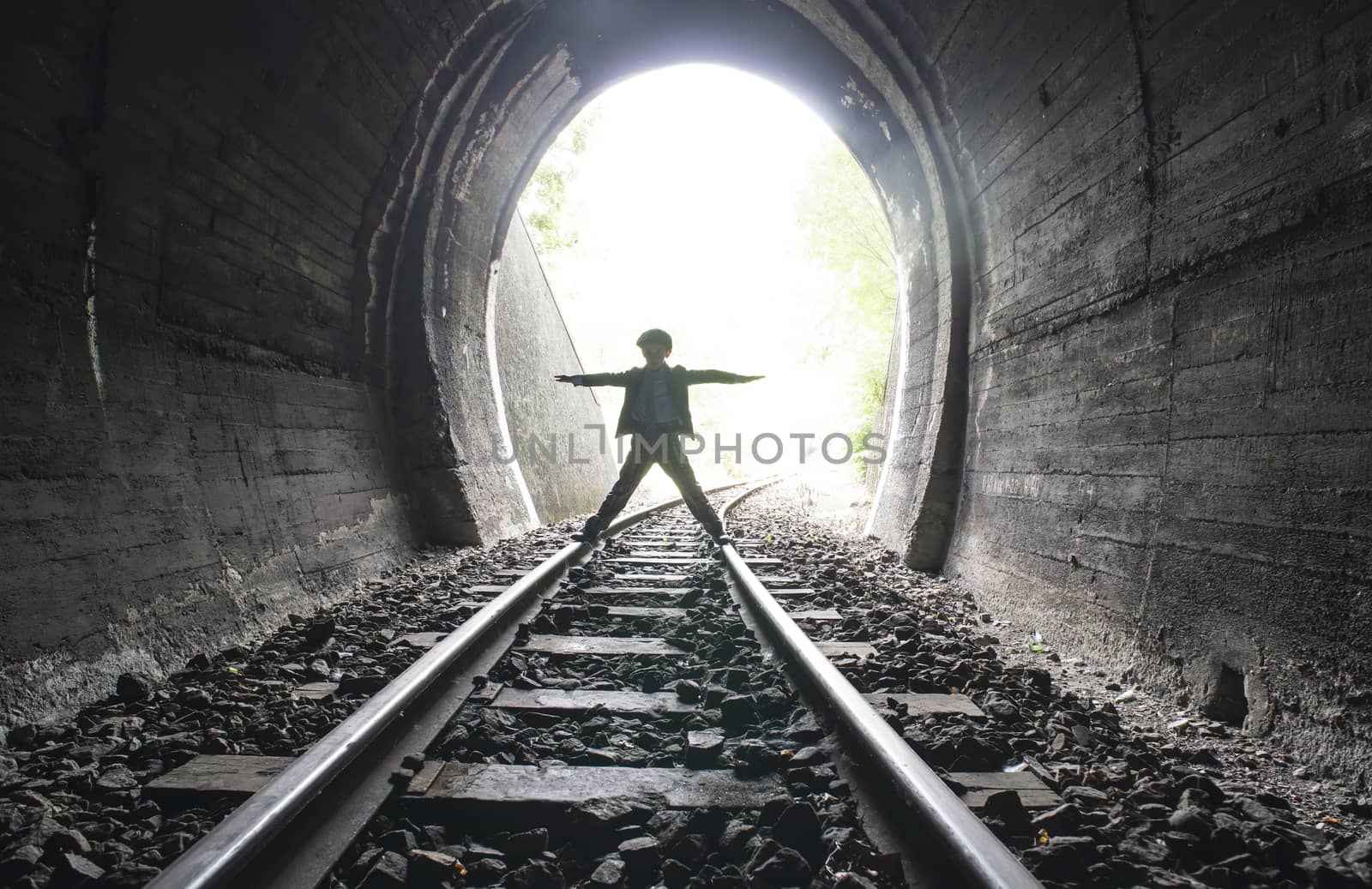 Child walking in railway tunnel. Vintage clothes