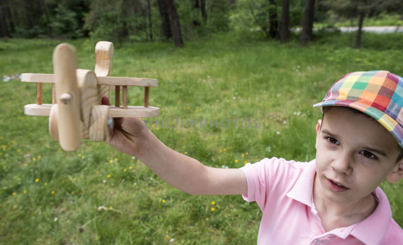 Child play with a wooden plane in the mountain. Forest