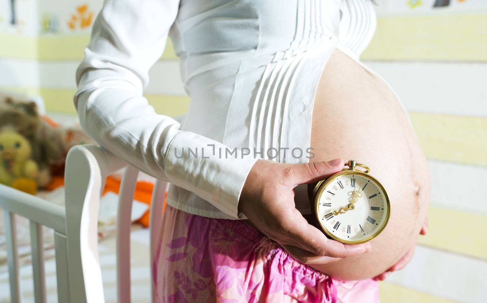 Pregnant women in a baby room. Watch