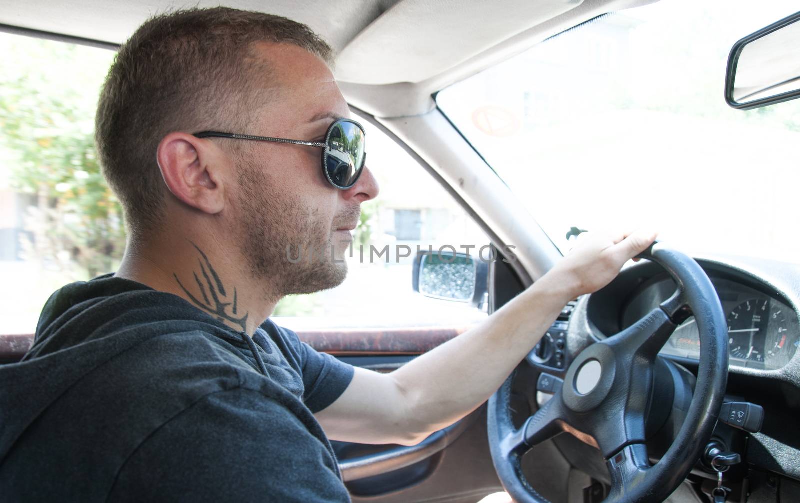 Boy with sunglasses driving a car. Close up