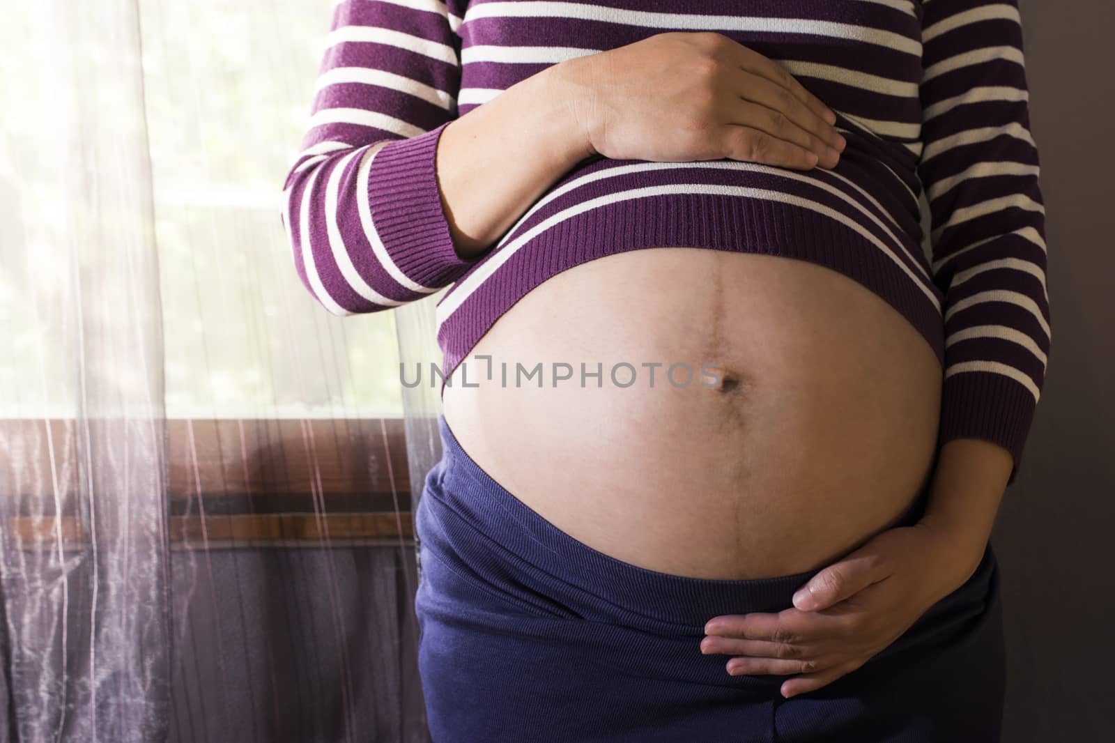 Pregnant women to the window. Violet colors