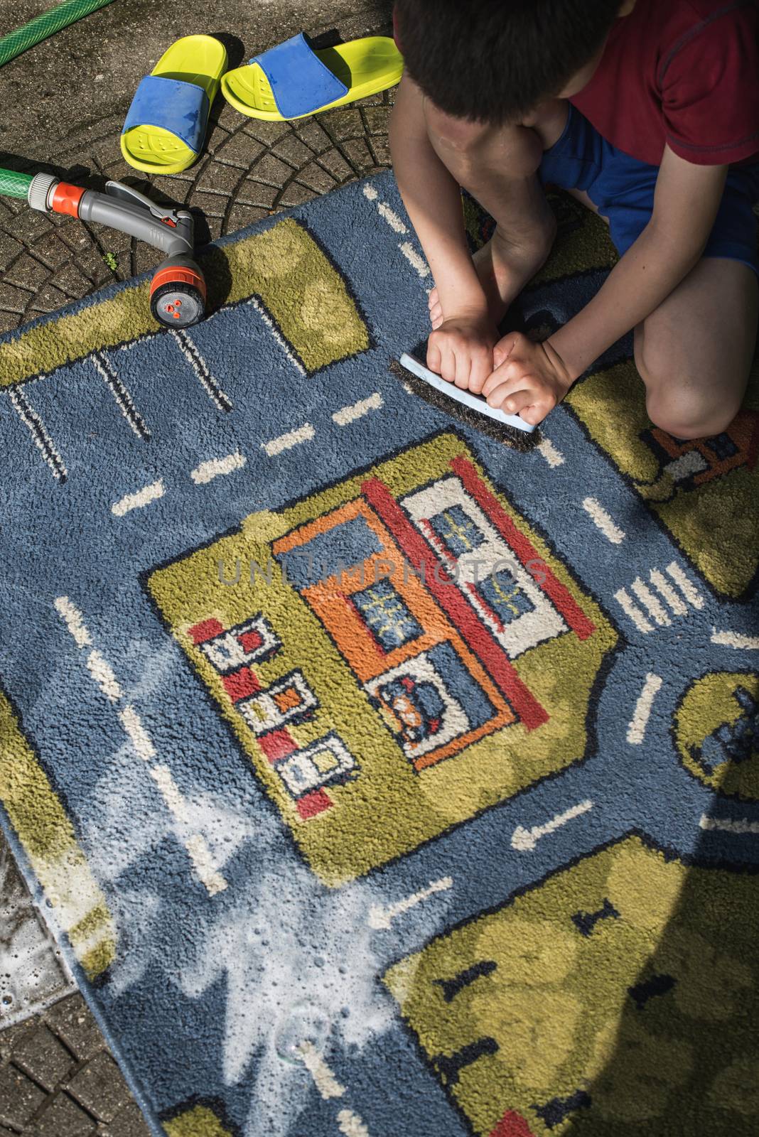 Child clean carpet. Exterior shot