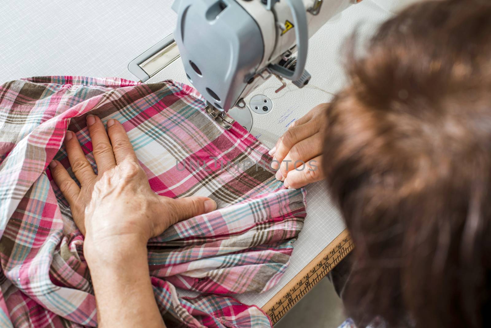 Women sew on sewing machine by deyan_georgiev