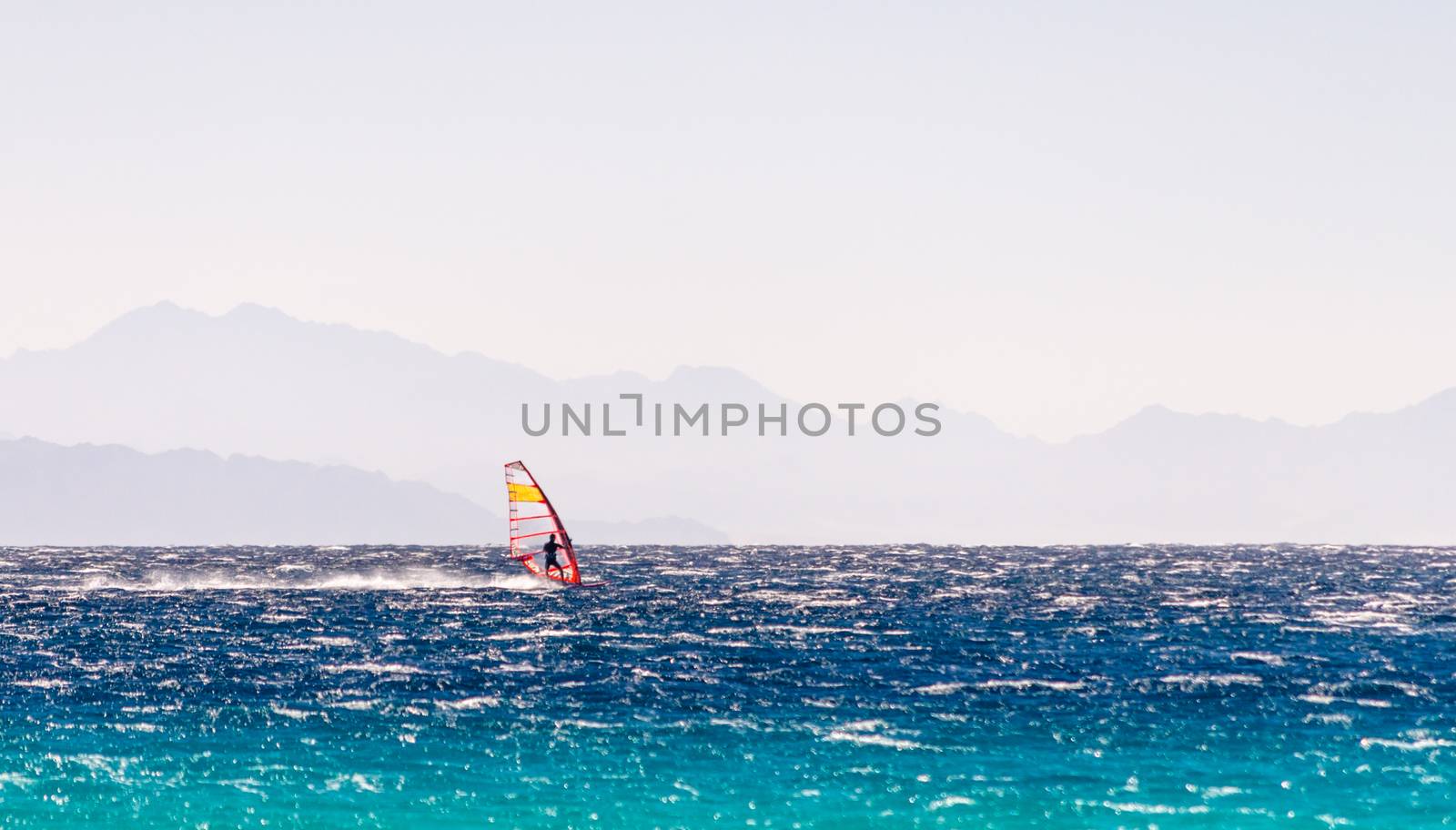 windsurfer rides on a background of high mountains in Egypt Dahab