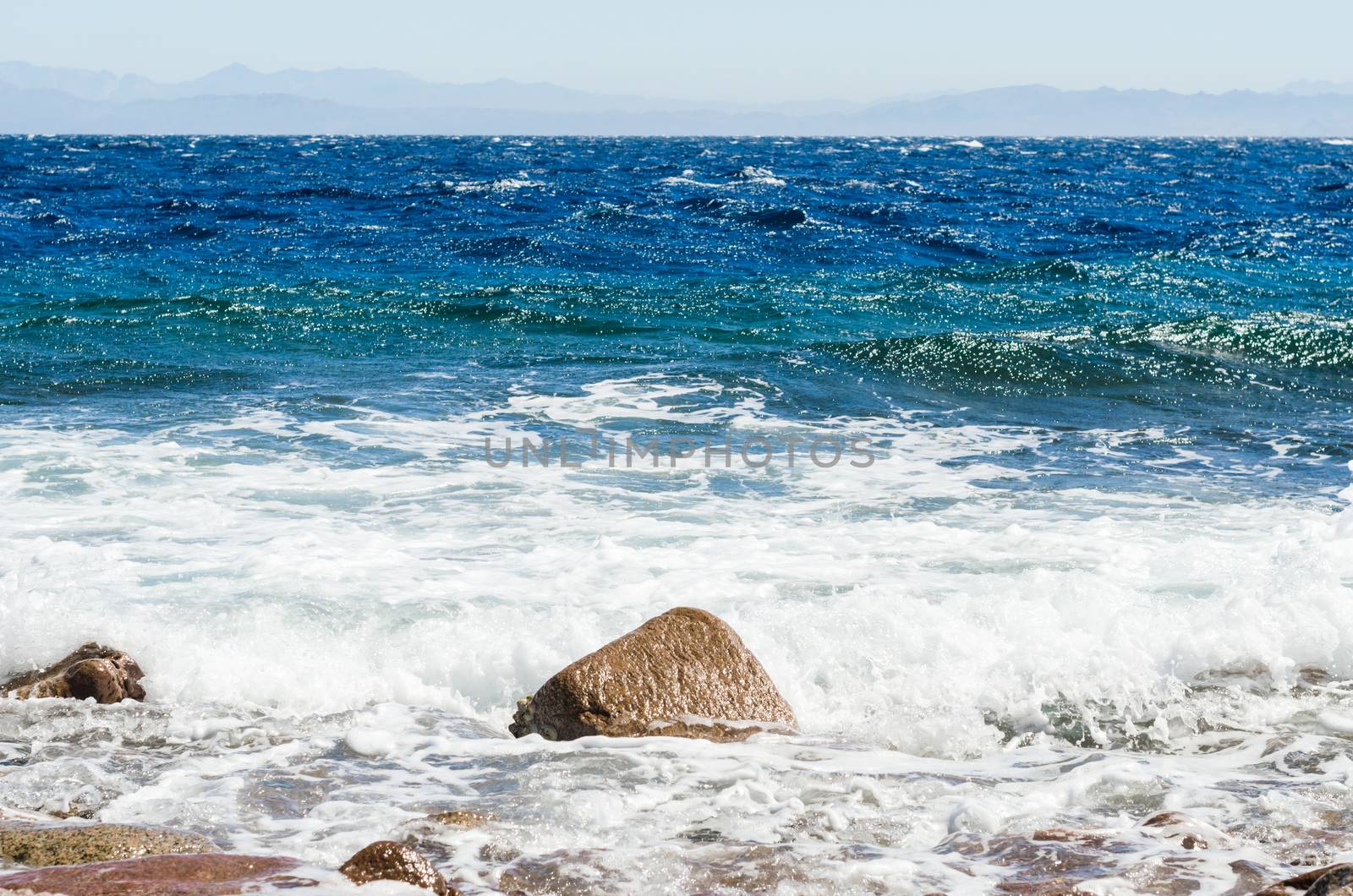 waves and splashes of sea surf and stones on the seashore