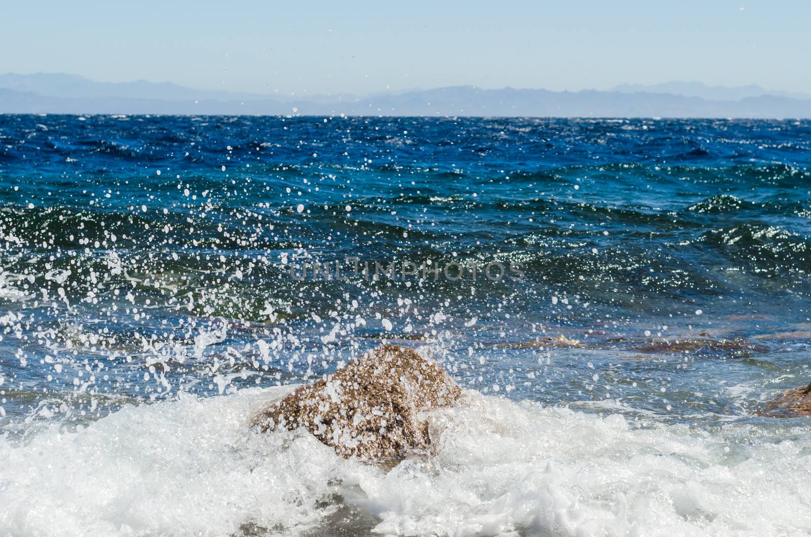 waves and splashes of sea surf and stones on the seashore
