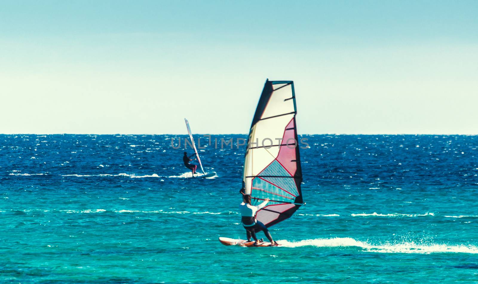 young surfer girl rides a sail in the Red Sea in Egypt Dahab
