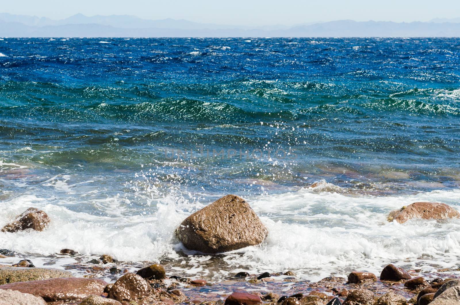 waves and splashes of sea surf and stones on the seashore
