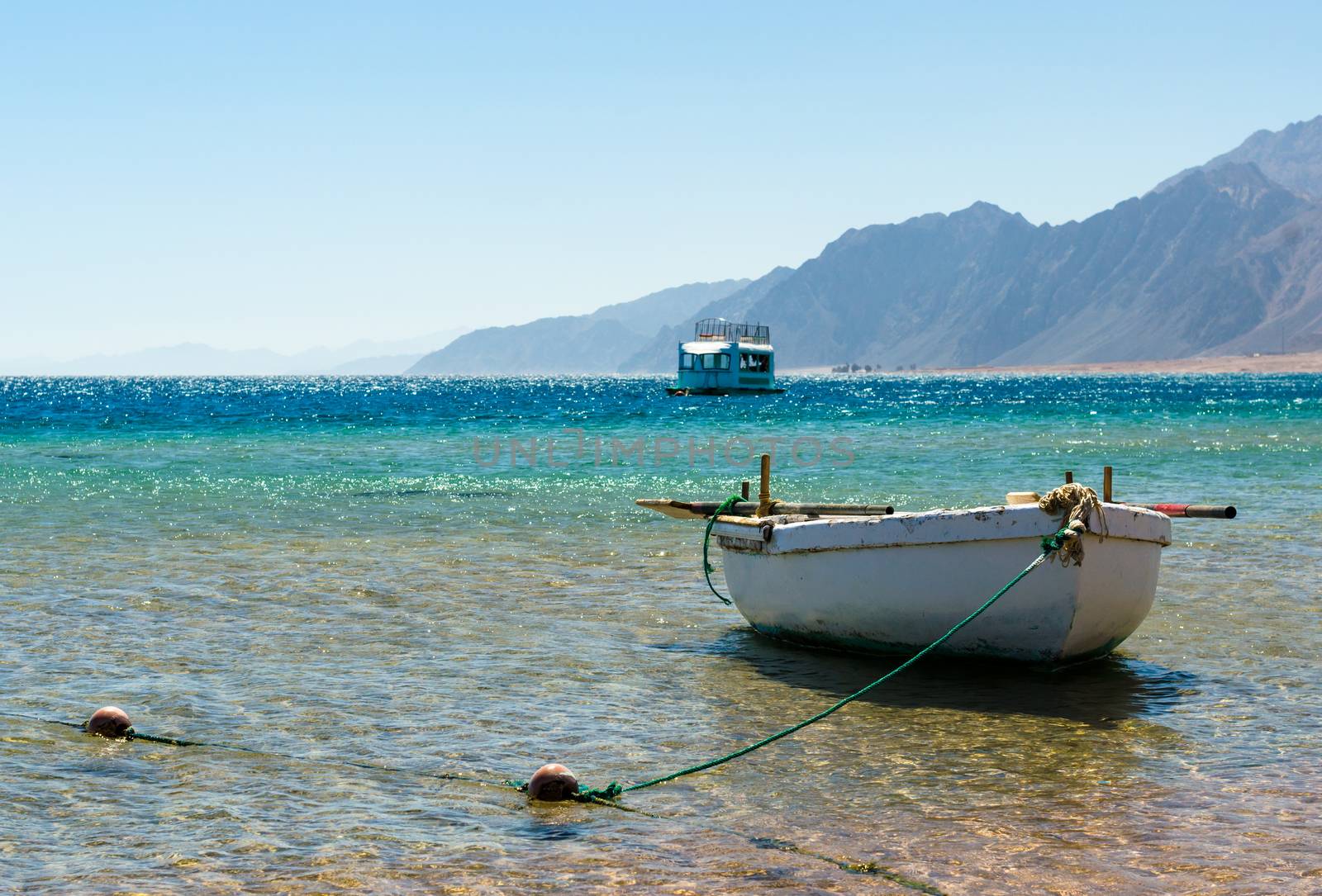 old wooden fishing boat in the sea against the backdrop of the high rocky mountains in Egypt Dahab