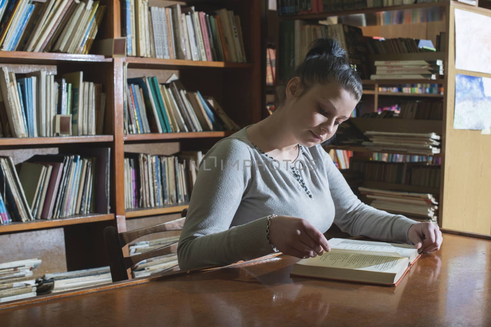 Student girl in a library. Looking at book