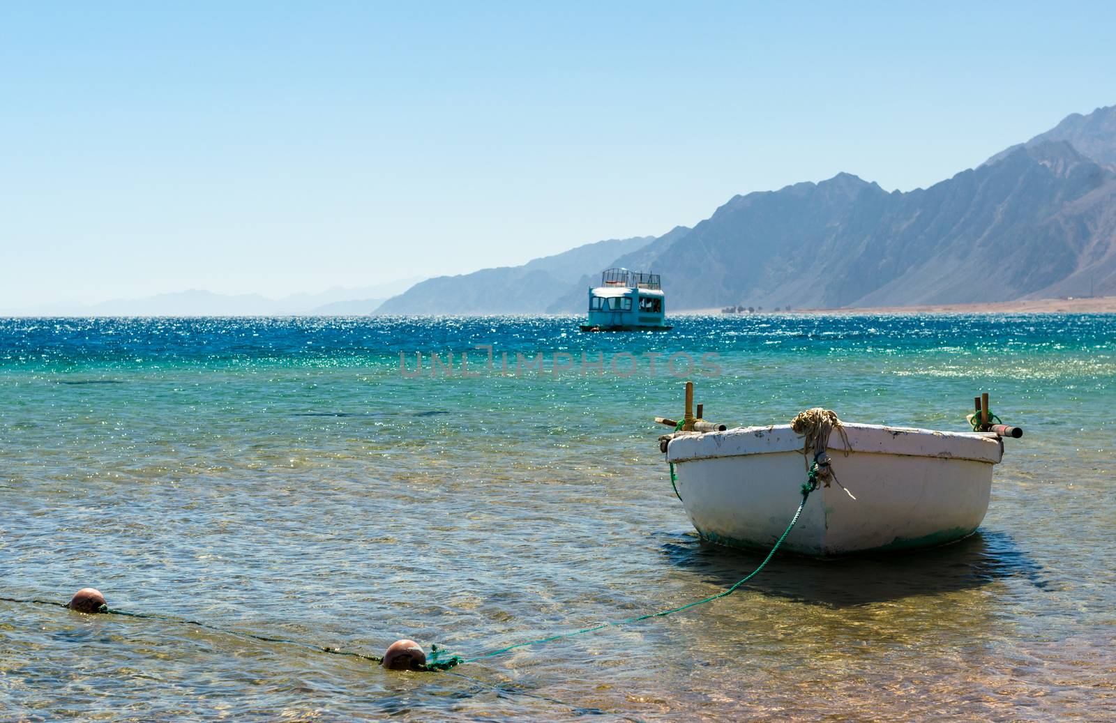 old wooden fishing boat in the sea against the backdrop of the high rocky mountains in Egypt Dahab