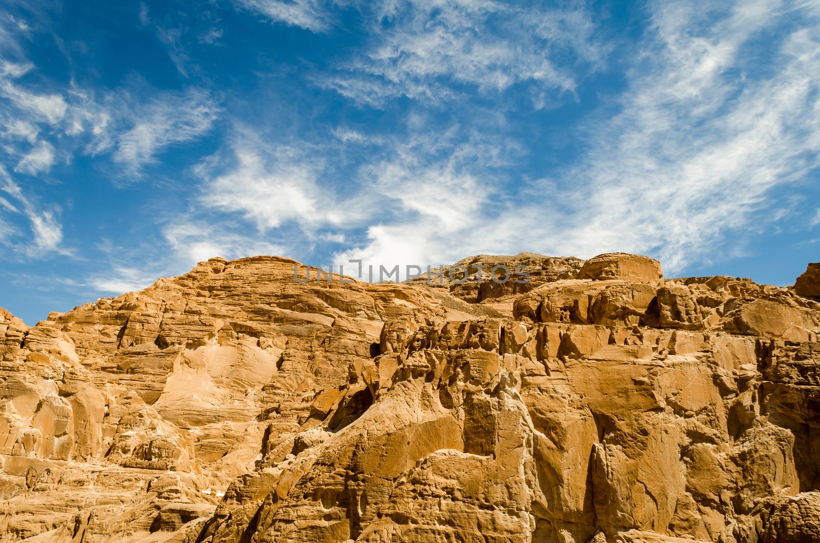 high rocky mountains in the desert against the blue sky and white clouds in Egypt Dahab