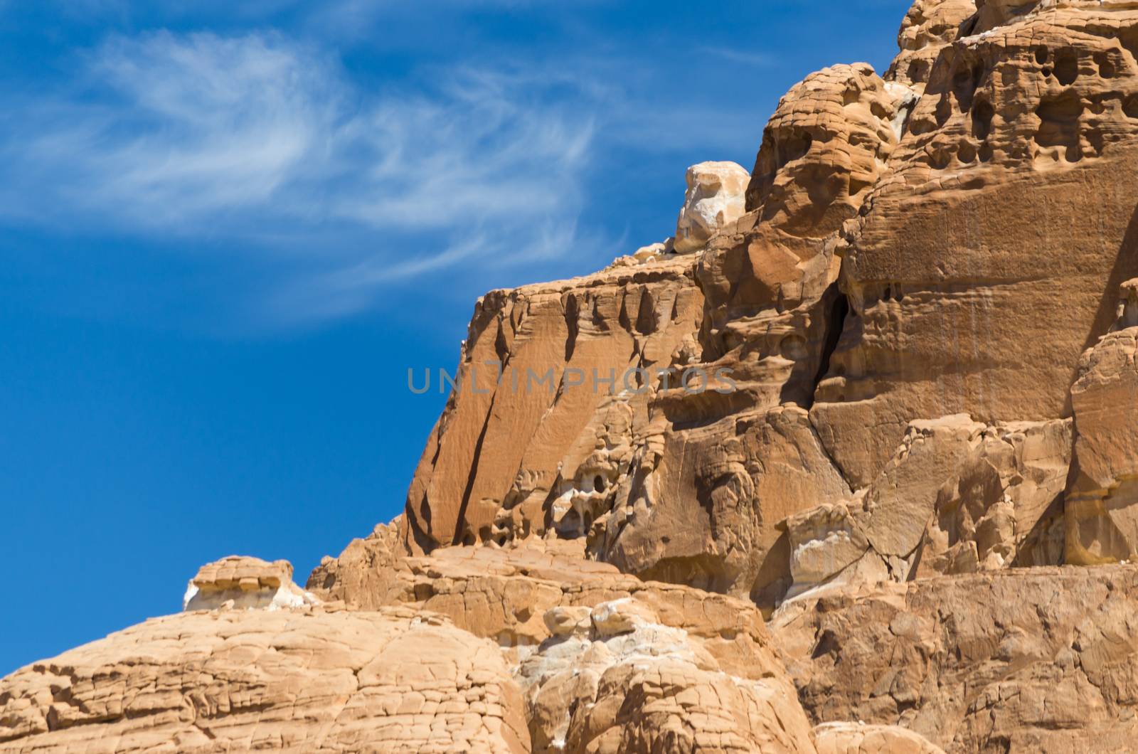 high rocky mountains in the desert against the blue sky and white clouds in Egypt Dahab