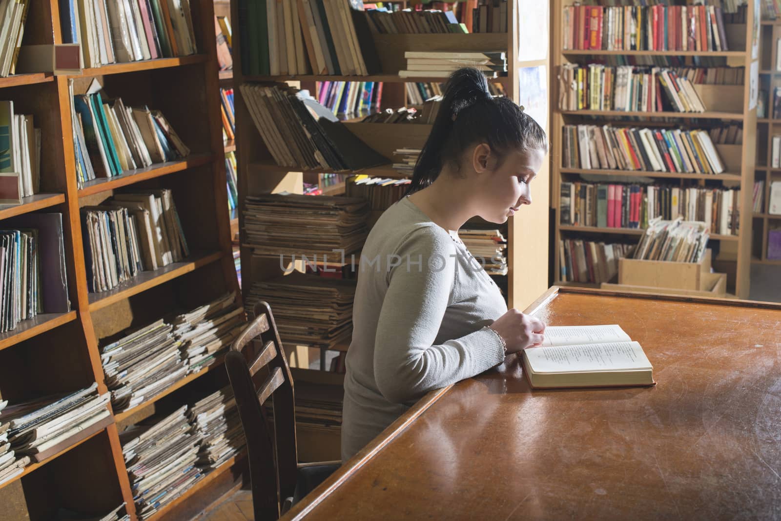 Student girl in a library. Looking at book