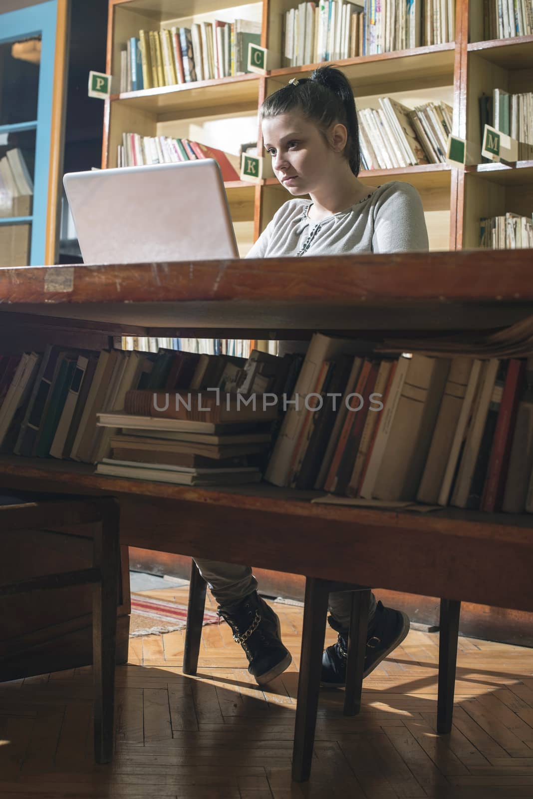 Student girl and laptop in a vintage library