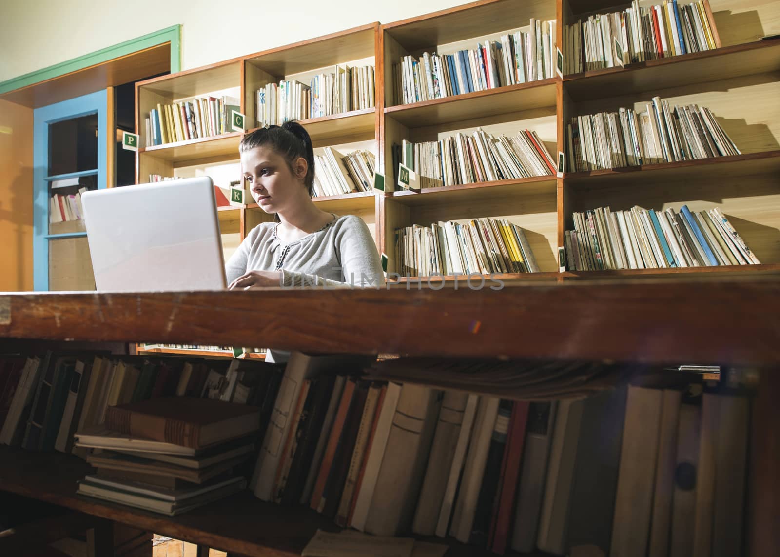 Student girl and laptop in a vintage library